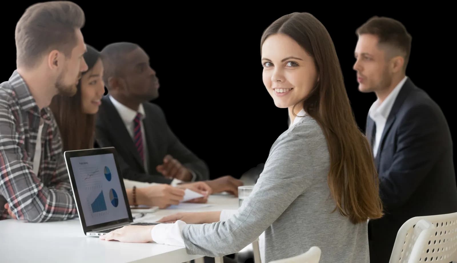A manager at a laptop in a meeting, looking up from the screen